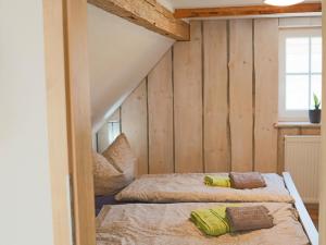 two beds in a room with wooden walls at Harzliebe in Hüttenrode