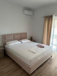 a bedroom with a large bed with white sheets at La casa de Alex in Sarandë