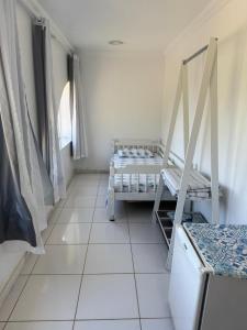 アハイアウ・ド・カボにあるHospedagem pontal do atalaiaのタイルフロアの客室で、ベッド1台が備わります。