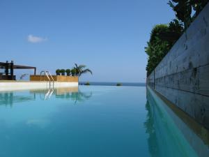 a swimming pool with blue water next to a wall at Warwick Palm Beach Hotel in Beirut