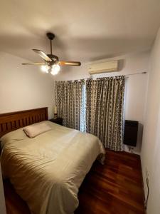 Mis Pasos por Urquiza في بوينس آيرس: غرفة نوم بها سرير ومروحة سقف