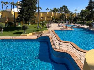 a swimming pool with blue water in a resort at Corralejo Atlantic Garden Andrew apartments Pool air conditioning in Corralejo +73 photos