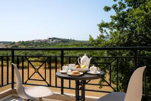 a table with a tea set on a balcony at Artemida Pansion Georgioupolis in Kournás +18 photos