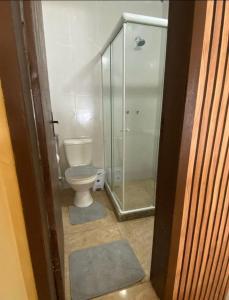 a bathroom with a toilet and a glass shower at Suíte Nascer do Sol in Angra dos Reis +4 photos
