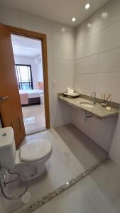 a bathroom with a toilet and a sink and a mirror at Conforto e praticidade em região central de Belém in Belém +23 photos