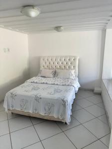a white bedroom with a bed in a room at Hospedagem pontal do atalaia in Arraial do Cabo