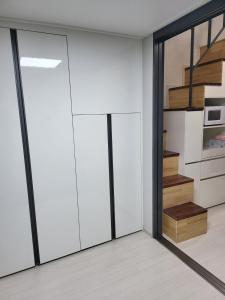 a kitchen with white cabinets and a sliding glass door at Stay in Seoul +4 photos