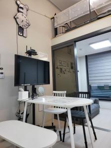 a living room with a white table and a tv at Stay in Seoul