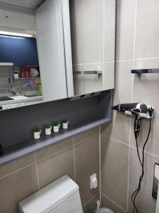 a bathroom with a toilet and a sink with plants at Stay in Seoul