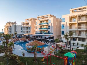a view of a resort with a pool and a playground at At Konan's in Vlorë
