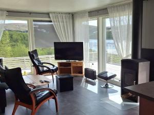 a living room with a television and a large window at 4 person holiday home in TANA in Tana