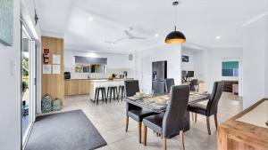 a dining room and kitchen with a table and chairs at "Tranquillity by the Sea" your Hideaway Bay Holiday Rental-Whitsundays in Hideaway Bay