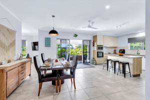 a kitchen and dining room with a table and chairs at "Tranquillity by the Sea" your Hideaway Bay Holiday Rental-Whitsundays in Hideaway Bay
