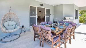 a dining room with a table and chairs at "Tranquillity by the Sea" your Hideaway Bay Holiday Rental-Whitsundays in Hideaway Bay