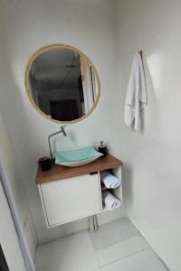 a bathroom with a mirror and a sink and towels at Conteiner Beira Mar Solar Analuz Prox Beto Carrero in Navegantes