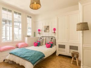 a bedroom with a bed with pink and blue pillows at Seaside Serenity in Normandy in Isigny-sur-Mer