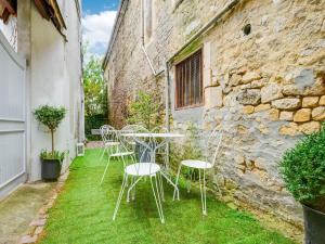a table and chairs on the grass in front of a building at Seaside Serenity in Normandy in Isigny-sur-Mer