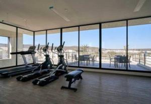 a gym with pilates equipment and a large room with windows at Casa de Descanso in La Cañada