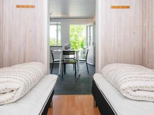 a bedroom with two beds and a dining room with a table at Seaside Escape in Kegnaes - By Traum Ferienwohnungen in Østerby