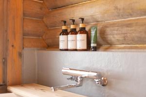 three bottles of wine sitting on a shelf above a sink at green bell in Myoko +154 photos