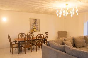 a living room with a couch and a table and chairs at Paradise Oasis in Negril