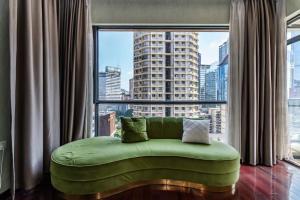 a green couch in a room with a large window at Jinxin Nanguo in Chongqing