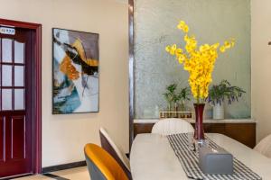 a dining room with a table with yellow flowers on it at Jinxin Nanguo in Chongqing