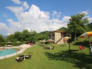 Una piscina con sillas y sombrillas al lado de un edificio. en Apartment in Marche with Pool & Terrace, en Apecchio 32 fotos más