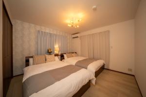 a bedroom with two beds and a window at アリュール別府 in Beppu