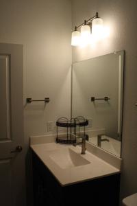 Un baño con lavabo y un espejo grande. en Amazing Katy home, en Katy