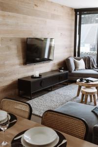 een woonkamer met een televisie en een bank bij Hygge East 302 St Falls in Falls Creek