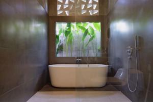 a bathroom with a bath tub with a mirror at Uluwatu Villa Special Price Aug, Sept, Oct in Ungasan