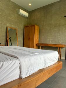 a bedroom with a bed with a wooden frame and a mirror at Uluwatu Villa Special Price Aug, Sept, Oct in Ungasan +11 photos