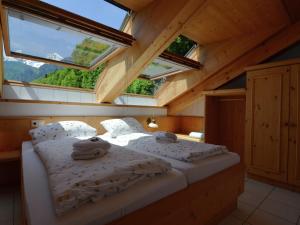 a bedroom with a bed in the attic with windows at Ferienhaus im Berchtesgadener Land in Schönau am Königssee