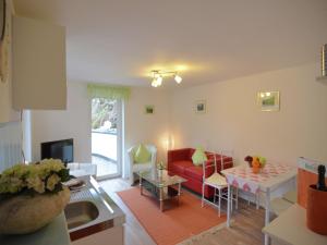 a living room with a red couch and a table at Gruppenferienhaus im Sauerland in Schmallenberg