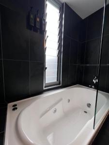 a white bath tub in a bathroom with a window at Crown on Darby Newcastle in Newcastle