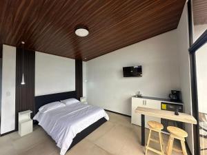 a bedroom with a bed and a table and a desk at Poás Natural in Alajuela