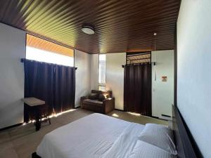 a bedroom with a large bed and a couch at Poás Natural in Alajuela