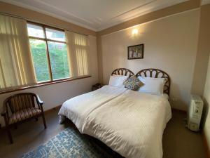 una camera da letto con un grande letto bianco con una finestra di Chansal Sky Sea 13 People - Shimla a Jāmb
