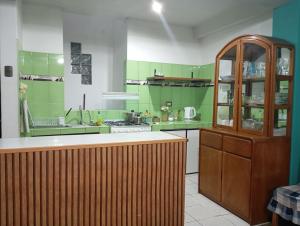a large kitchen with green walls and a wooden counter at APARTAMENTO Acogedor cerca del aeropuerto Cusco in Cusco