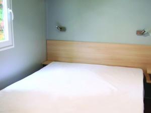 - un lit blanc dans une chambre avec fenêtre dans l'établissement Mobil Home 34m² avec Terrasse pour 6 à Dévillac - API-1-52-331, à Dévillac 21 autres photos