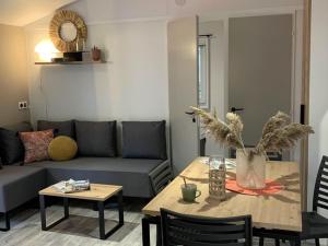 ein Wohnzimmer mit Tisch und Couch in der Unterkunft Mobil-home avec Terrasse pour 5 à Limeuil - API-1-52-425 in Limeuil