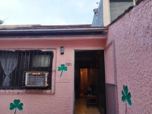 クユトランにあるBungalows los trébolesの側面にクローバーが描かれたピンク色の家