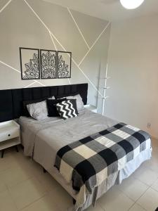 a bedroom with a bed with a black and white blanket at Village Ducado in Mangaratiba +67 photos