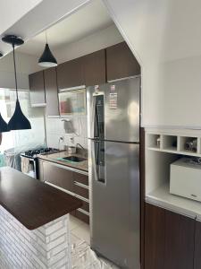 a kitchen with a stainless steel refrigerator and a counter at Village Ducado in Mangaratiba