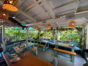 a restaurant with tables and benches and plants at DJs Beach Resort in Union