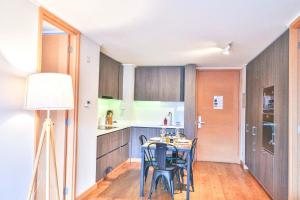 a kitchen with a table and chairs in a room at HOM I Conjunto frente a la Costanera 2D2B in Puerto Varas