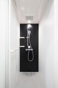 a bathroom with a shower in a black wall at HOTEL TAVINOS Hamamatsucho - Vacation STAY 51014 in Tokyo