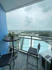 a balcony with a table and chairs and a view of the water at Condo in San Fernando Azure North with Home Theater in San Fernando