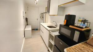 a small kitchen with a sink and a microwave at Condo in San Fernando Azure North with Home Theater in San Fernando